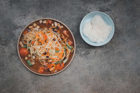 Som tam Thai or Green papaya salad with sticky rice on a stone background.の写真素材