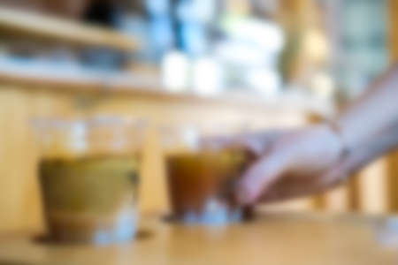 Blur background of woman pick up cup of coffee. Blur background