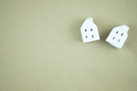 Simply flat lay design with miniature white tow toy model houses on brown background. Dream home concept. Flat lay top view copy spaceの写真素材