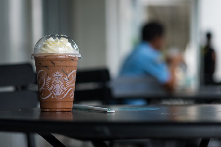 Samut Prakan, Thailand - November 11, 2021 : Glass of Starbuck coffee iced mocha on top with whipped cream at Starbucks coffee shop on table outdoor. Starbucks is the world's largest coffeehouse and is highly popular.のeditorial素材