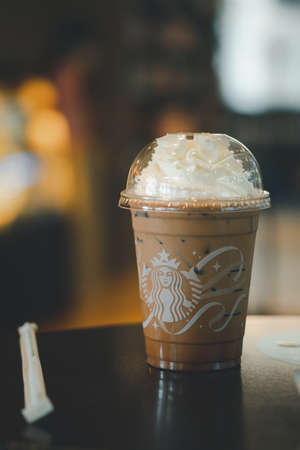 Bangkok - Thailand, November 6, 2021 : A glass of iced Mocha coffee topping with whipped cream on table at Starbucks coffee shop. Starbucks is the world's largest coffeehouse and is highly popular.のeditorial素材