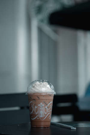 Samut Prakan, Thailand - November 6, 2021 : Glass of Starbuck coffee iced mocha on top with whipped cream at Starbucks coffee shop on table outdoor. Starbucks is the world's largest coffeehouse and is highly popular.のeditorial素材
