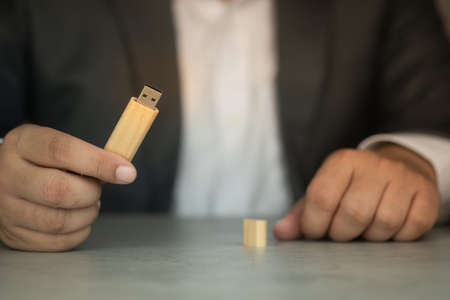 Man in suit holding USB cable. Show the symbol of technology and data.の写真素材