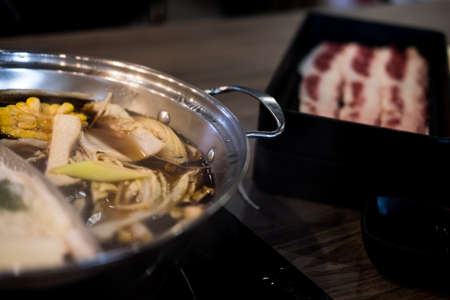 Close up view of hot pot or Sukiyaki with raw beef background.の写真素材