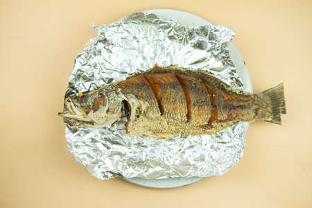 Crispy golden deep fried whole sea bass with fish sauce served on foil paper. This is recommend dish...