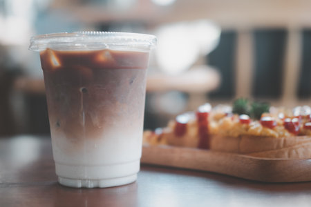 Ice coffee with milk in takeaway cup showing separately in a layer the bottom as milk top by coffee shotの写真素材