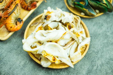 Delicious slice of grilled squid with many seafood around