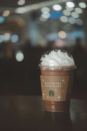 Samut Prakan, Thailand - December 11, 2021 : Glass of Starbuck coffee iced mocha on top with whipped cream at Starbucks coffee shop on table outdoor.のeditorial素材
