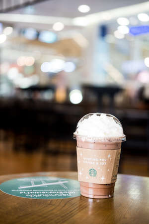 Samut Prakan, Thailand - December 15, 2021 : Glass of Starbuck coffee iced mocha on top with whipped cream at Starbucks coffee shop on table outdoor.のeditorial素材