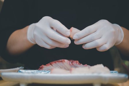 Sushi master chef preparing fresh tuna sashimi in plate to served to a customer at Japanese restaurantの写真素材