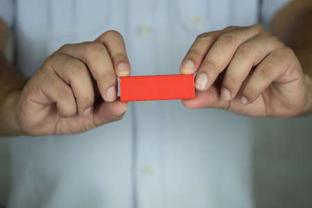 Hand of a doctor holding a red wooden block. Close-upの写真素材