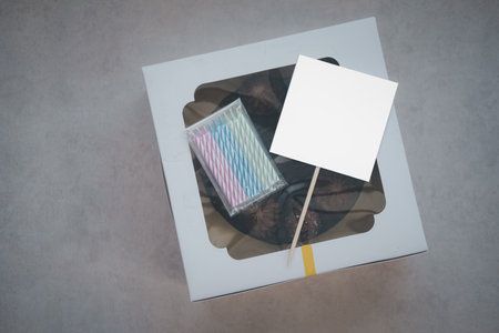 A present box full of big cakes with empty tags and a candle for a birthday party. Gift box with...
