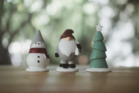 Christmas little toy placed on wood table against nature backgroundの写真素材