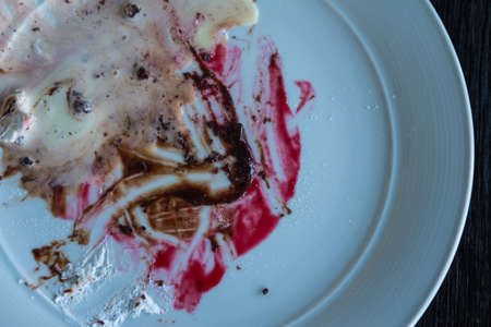Dirty dishes of blueberry and chocolate sauce  stains in white dish after eatingの写真素材