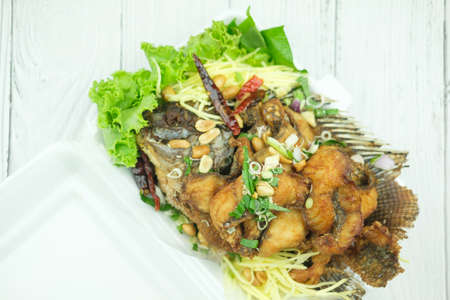 Fried fish with salad mixed herbs Thai food delicious main course dish decorated with vegetable in boxの写真素材