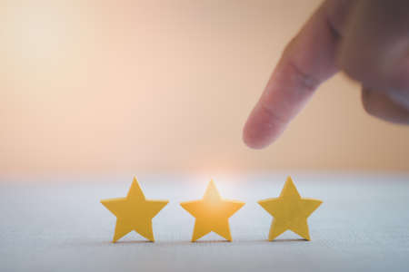 Man pointing yellow star shape in the center. Rated best service excellence concept.