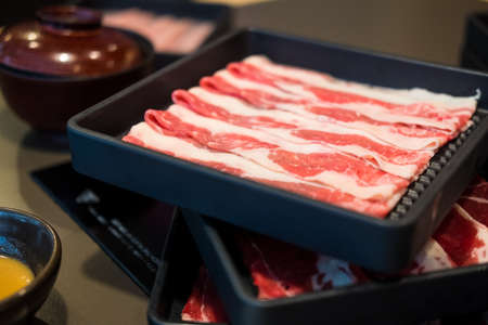 Premium Japanese meat sliced wagyu marbled beef in the black tray for Sukiyaki and Shabu or Yakinikuの写真素材