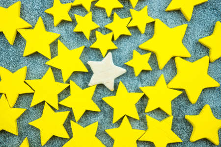 Yellow star with one wood star in middle standing out farther than the rest. Top view