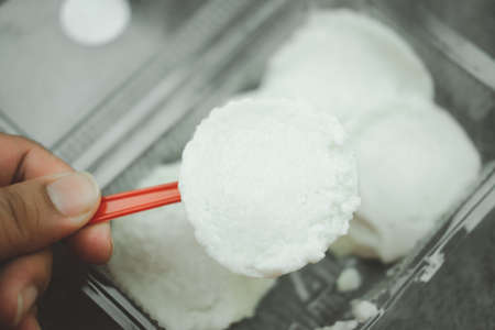 Man is eating Thai coconut milk custard in small porcelain cup. Thai called Khanom Thuai. Thai dessert.の写真素材