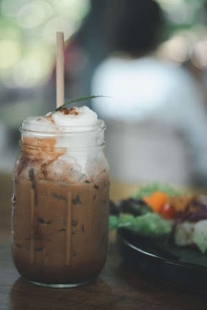 Ice Mocha coffee in glass on wood table at cafe. Cold summer coffeeの写真素材