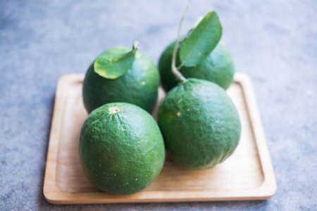 A group of fresh green big lemon on wood tray.の写真素材
