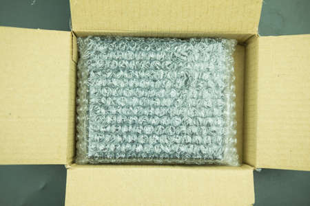 Plastic air  wrapped items in a brown cardboard box, ready to be shipped.