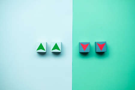 Wood cube block with down and up arrows icon. Conceptual image of stock market and economy down and growthの写真素材