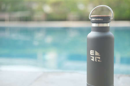 Bangkok, Thailand - April 30, 2022 : Black glossy metal water bottle with wood cap and handle, that...