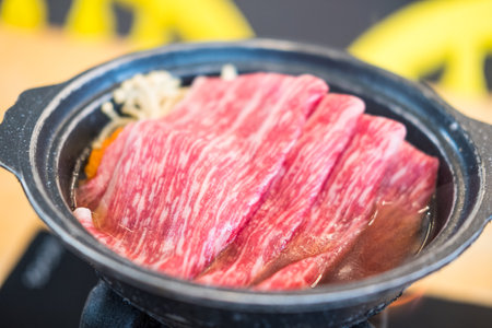 Sukiyaki is a popular one-pot meal. The main ingredient is thin sliced beef, and eating with sukiyaki sauce and lots of vegetables in shabu restaurantの写真素材