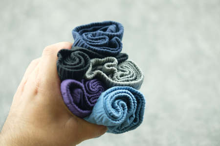 Man hands hold stock of  underwear pants for men. Concept of clothes and costume. Men fashion,...