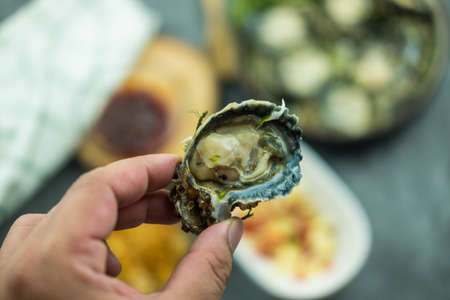 Man holding raw fresh oyster. Close up