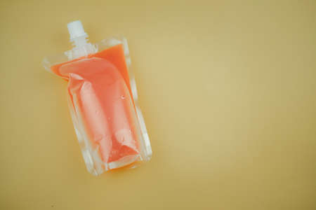 Fruit punch in packaging for takeaway on a yellow background