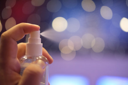Hand a man press the alcohol spray bottle for protection and quarantine the pandemic virus on bokeh backgroundの写真素材