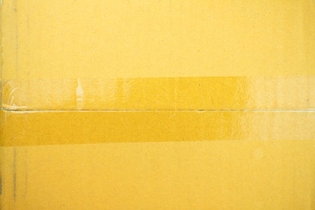 Sticky transparent tape on a cardboard box. Adhesive tape on the cardboard surface