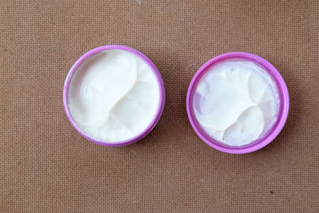 A clay, pomade, wax, gel or mousse from round pink box for styling his hair after barbershop hair...