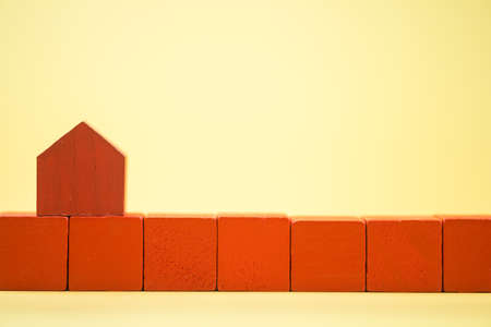 Red house model on a row red wooden blocks. The concept of new real estateの写真素材