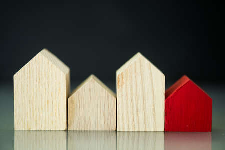 A row of wood home and a one red house. A symbol for the best home, home purchase mortgage real estate conceptの写真素材