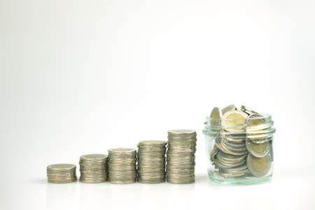 Stacking of money coins as step and a glass jar with coins for saving money, concept idea investment, funds and step to keep money.の写真素材