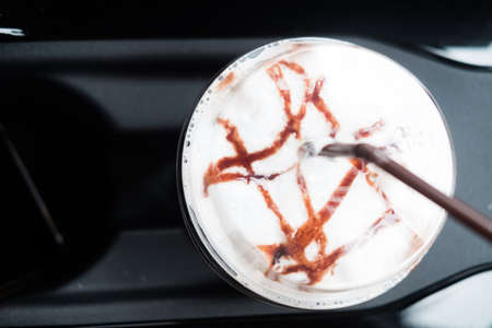Iced Mocha coffee in the personal car from the drive-through coffee shop, closeup shot of cup in the...