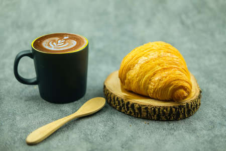 Hot mocha coffee cup and fresh croissant. Healthy eating and sweet food concept. French breakfast.