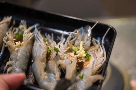 Cutting half river prawn on black tray ready to grillの写真素材