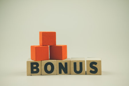 Wooden blocks with the word bonus. Getting benefits and extra points. Bonus wage. Benefit, cashback concept.の写真素材