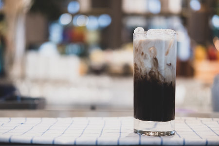 Iced coffee with a layer fresh milk it showing the texture and refreshing look of the drink. Close...