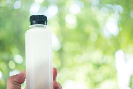 Fresh organic coconut water in a plastic bottle on hand. Organic healthy drinkの写真素材