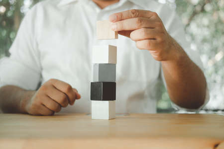 Man piling up and stacking a wooden block on wood blockの写真素材