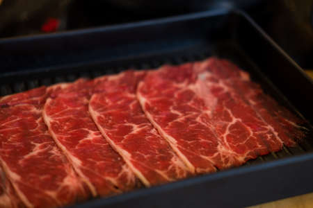 Thinly sliced of raw beef on tray prepare for customer cook. Japanese hot pot also known as Shabu Shabu or Sukiyaki is Japanese style is popular local food in asian countries.の写真素材