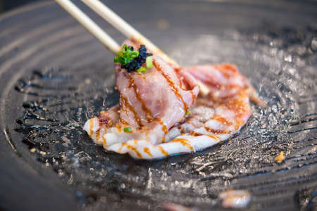 Use chopsticks eating A5 grade Japanese wagyu beef sushi from black dishの写真素材