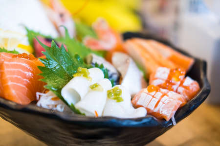 Fresh sashimi, raw fish mixed in traditional Japanese style a colorfully decorated large plateの写真素材