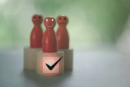 Wooden red dolls, emotional faces, customer evaluation and satisfaction with products and services, improving services and products and services.の写真素材