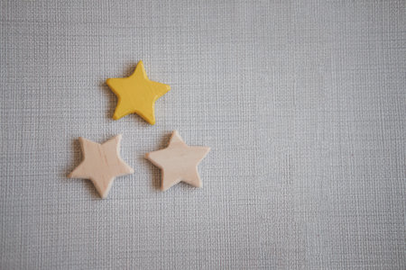 Wooden three star shape and one star painted yellow. The best excellent business services rating customer experience concept.の写真素材